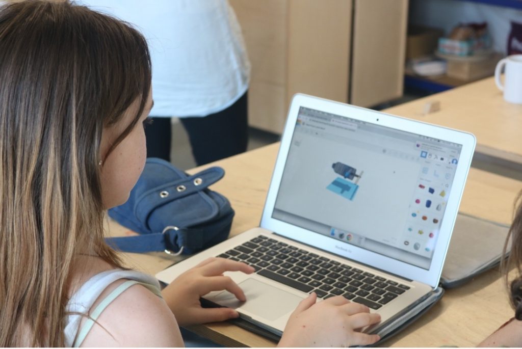 A young person on a macbook using tinkerCAD